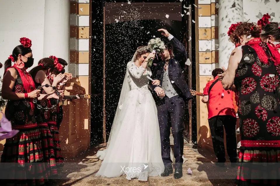 Los novios salen de la ceremonia entre una lluvia de pétalos y confeti