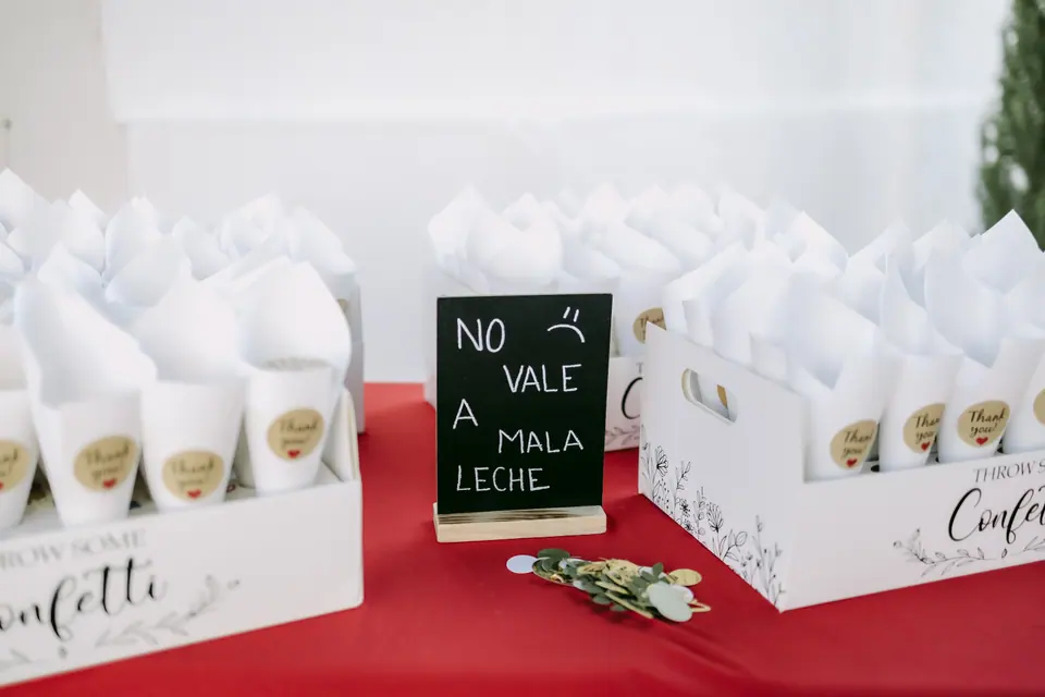 Mesa de regalos con bolsas y pizarra «No vale mala leche»