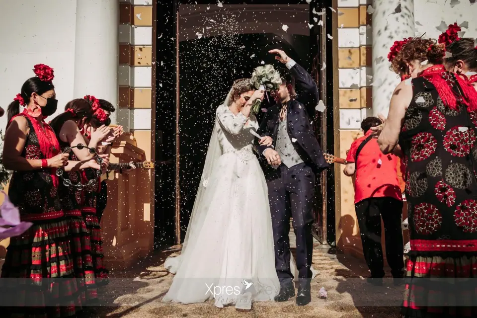 Los novios salen de la iglesia mientras los invitados lanzan arroz
